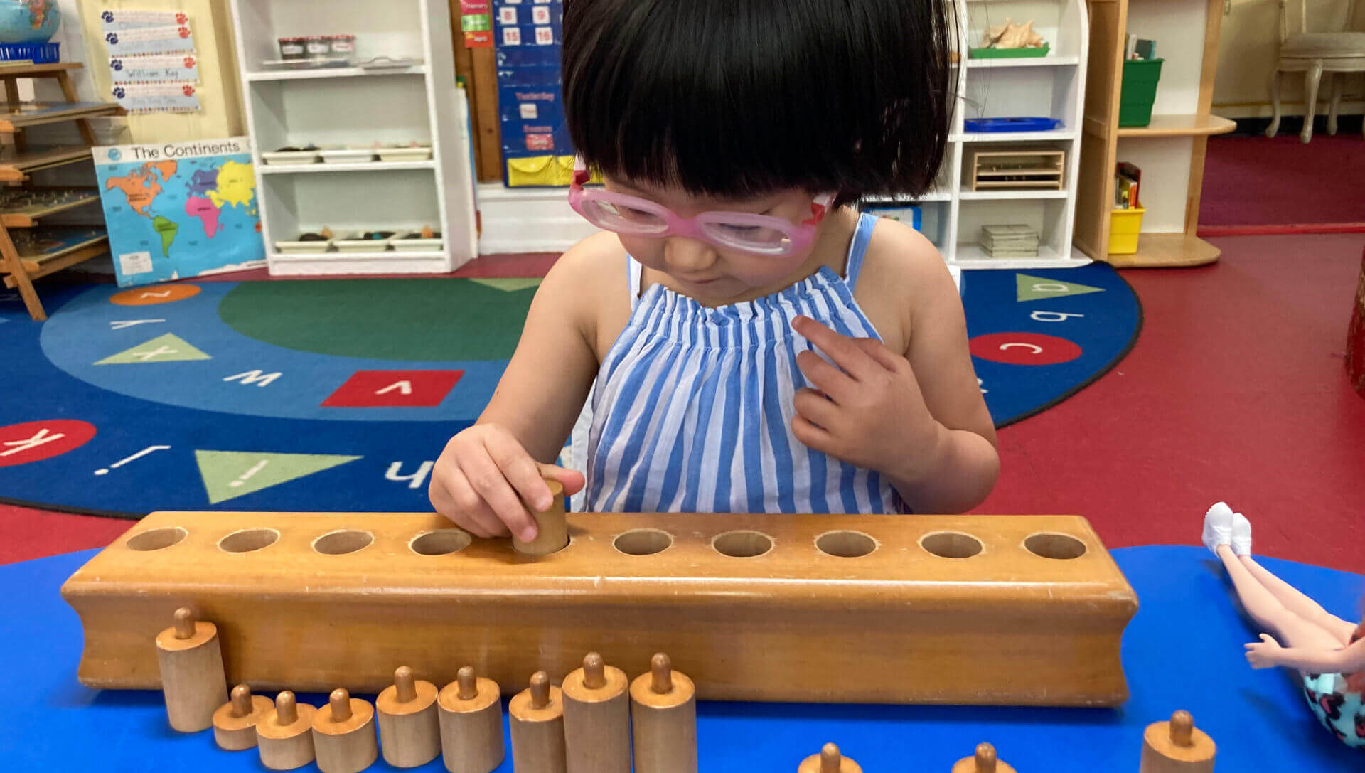 A young girl with glasses happily engages in play