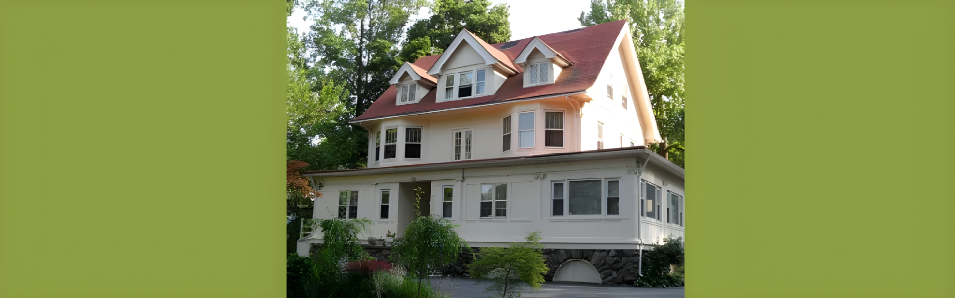 A grand house showcasing a bold red roof and classic white trim
